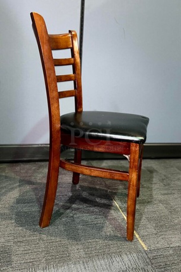 Wooden restaurant chair with black leather seat- 18.5" W x 33.5" L x 15" D. In good used condition, no broken pieces but have some marks and scuffs from normal wear. BIDX6 - Image 2 of 3