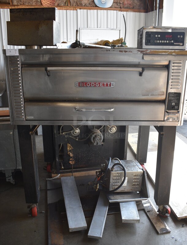 Blodgett Model 1048DD/AA-S Stainless Steel Commercial Natural Gas Powered Single Deck Pizza Oven on Metal Legs w/ Commercial Casters. Comes w/ 2 Cooking Stones. Unit Has An Added Humidity Steam Box Attachment For Donut Baking. 80,000 BTU. 60.5x45.5x72.5