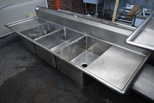Stainless Steel Commercial 3 Bay Sink w/ Dual Drain Boards, Handles, Faucet and Spray Nozzle Attachment. No Legs. Bays 20x28. Drain Boards 18.5x20 - Image 1 of 6