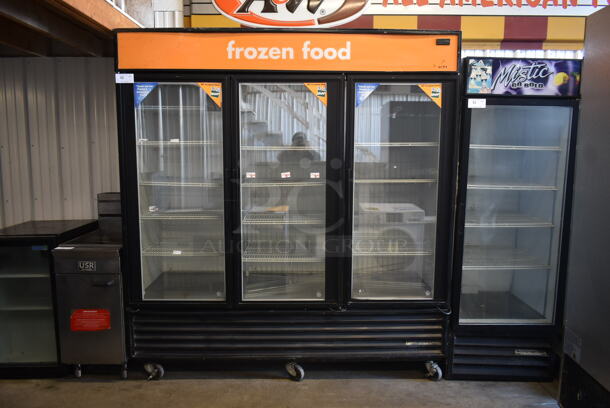 2012 True GDM-72F Metal Commercial 3 Door Reach In Freezer Merchandiser w/ Poly Coated Racks on Commercial Casters. 115/208-230 Volts, 1 Phase. 