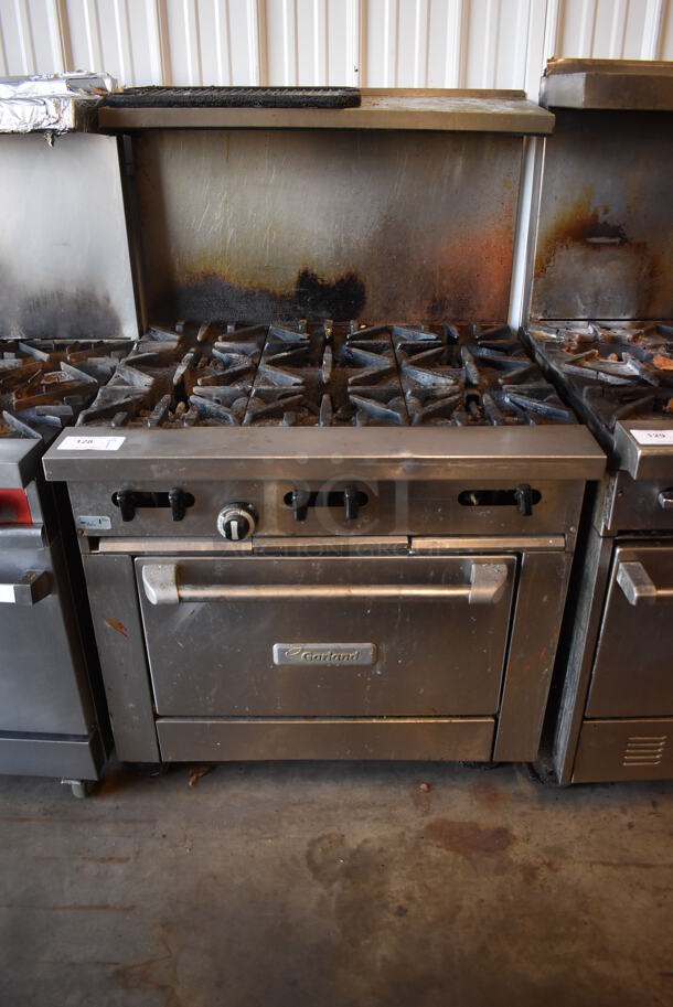 Garland Stainless Steel Commercial Natural Gas Powered 6 Burner Range w/ Oven, Over Shelf and Back Splash on Commercial Casters. 35.5x35x57