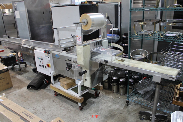 PFM Packaging 30 M Metal Commercial Floor Style Horizontal Form Fill and Seal / Horizontal Flow Wrapper Machine on Commercial Casters. 220 Volts, 1 Phase.  - Image 1 of 11