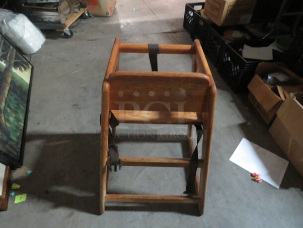 One Wooden High Chair With Safety Straps.