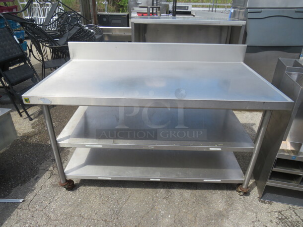 One Stainless Steel Table With 2 Stainless Steel Undershelves, And Back Splash, On Casters. 60X32X40