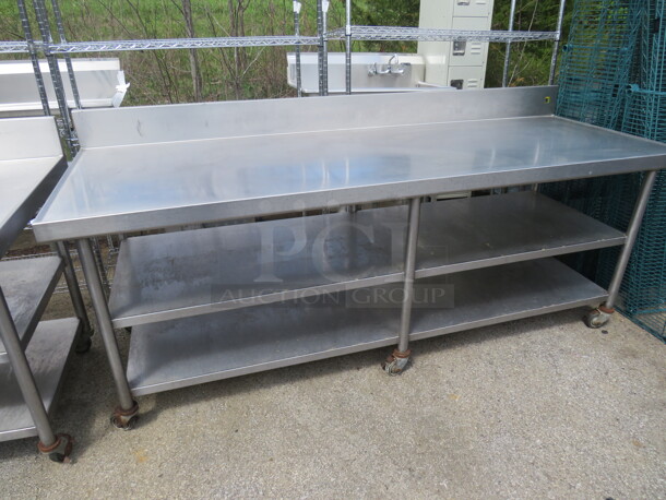 One Stainless Steel Table With 2 Stainless Steel Undershelves, And Back Splash, On Casters. 90X32X40
