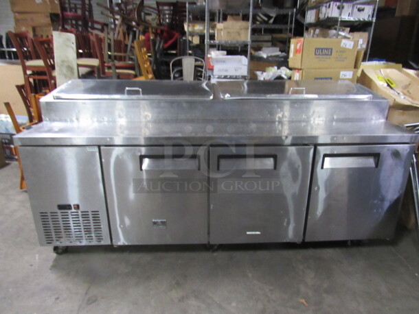 One Stainless Steel  Kelvinator 3 Door Refrigerated Prep Table With 3 Racks On Casters. Model# KCPT92.12. 92X33X42 - Image 2 of 3