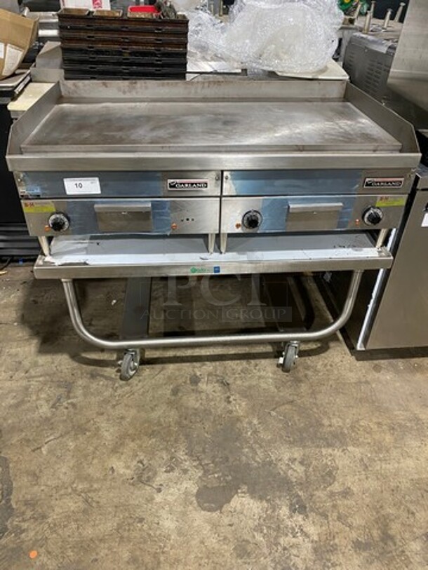 WOW! NEW OUT OF THE BOX! Garland Commercial Countertop Electric Powered Flat Top Griddle! With Back And Side Splashes! On Legs! On Equipment Stand! All Stainless Steel! On Casters! Model: E2448G SN: 0404ME0033 208V 60HZ 3 Phase