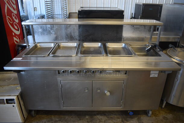 Stainless Steel Commercial Floor Style Electric Powered Steam Table w/ 5 Drop In Bins, Over Shelf and 2 Doors on Commercial Casters. 208 Volts, 1 Phase. 74x36.5x51