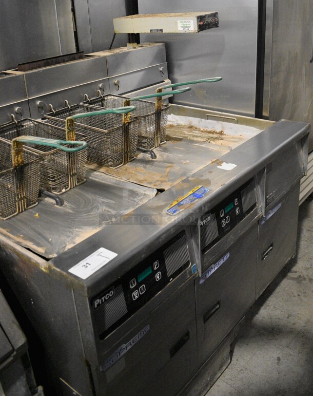 2013 Pitco Frialator Model SSH55 Stainless Steel Commercial Natural Gas Powered 2 Bay Deep Fat Fryer w/ 4 Metal Fry Baskets, 2 Lids, Right Side Dumping Station and Warming Strip on Commercial Casters. 80,000 BTU. 47x35x52