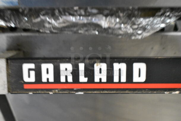 Garland Metal Commercial Natural Gas Powered 6 Burner Range w/ Flat Top Griddle, 2 Ovens, Back Splash and Over Shelf on Commercial Casters.  - Image 2 of 11