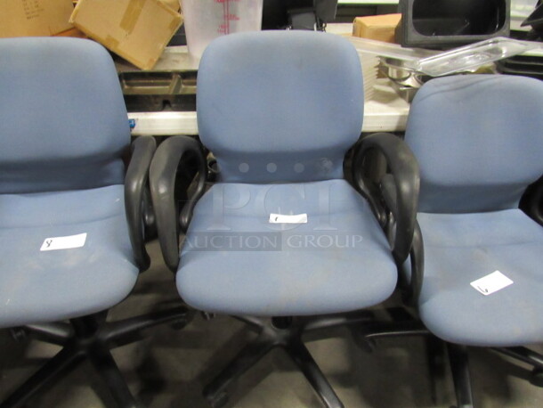 One Blue Cushioned Office Chair On Casters.
