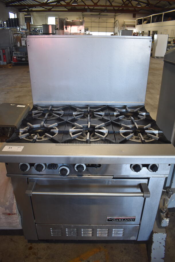 Garland H286 Stainless Steel Commercial Floor Style Natural Gas Powered 6 Burner Range w/ Oven and Back Splash on Commercial Casters. 36x33x58