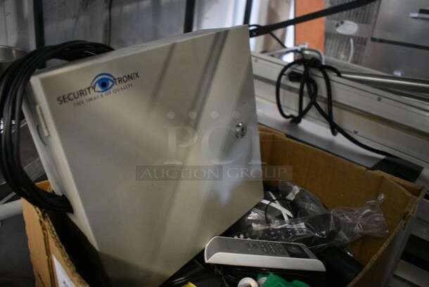 ALL ONE MONEY! Lot of Various Items Including a Security Tronix Box, Remote Controls and Green T-Shirt. - Image 2 of 4