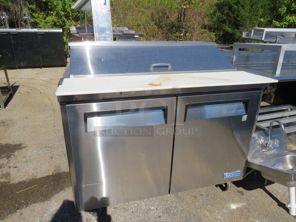 One WORKING 2 Door Turbo Air Refrigerated Prep Table With 2 Racks, A Cutting Board On Casters. Model# MST-48. 115 Volt. 48X32X35 - Image 1 of 3