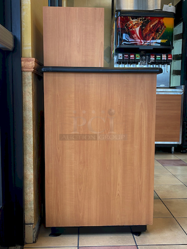 BEAUTIFUL! Plymold Round Drop Top Waste Receptacle with Tray Shelf, With 35 Gallon Liner. 
26x26x48

High pressure commercial laminate top and cabinet
Molded polyurethane edge designed for high traffic areas
8" Drop hole with Dur-A-Edge finish
Provides hygienic seal between laminate and receptacle edge
1.5" Radius corners on top
Rolled edge profile
1-1/8" thick 45 lb density particleboard core
Underside has phenolic backer to protect from moisture
Includes 35 gallon liner with casters
Tray shelf is 21.5"W x 11.25"D
Satin Nickel hinge and door pull
Leveling glides included - Image 2 of 4