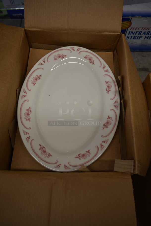 2 Boxes of 12 BRAND NEW! White Ceramic Oval Plates w/ Red Pattern on Rim. 2 Times Your Bid!