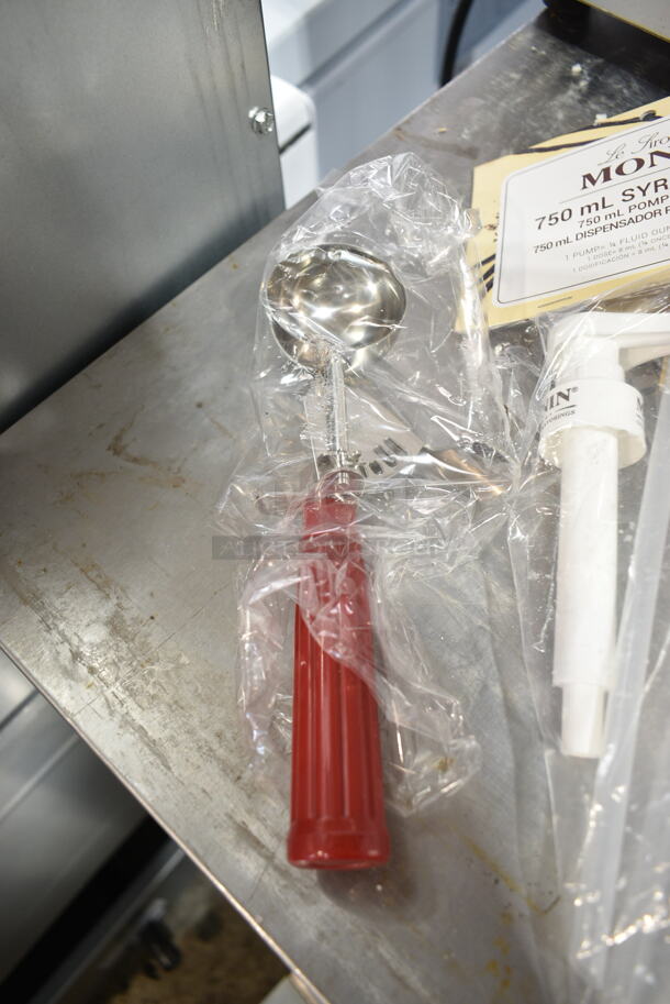 4 BRAND NEW SCRATCH AND DENT! Items Including 407TPD24RD Choice #24 Red Thumb Press Disher - 1.33 oz., 714QV12 Outset® QV12 18" Stainless Steel Ultra-Thin Slotted Turner with Bamboo Handle, Monin Syrup Pumps, Strainer. 4 Times Your Bid!  - Image 2 of 9