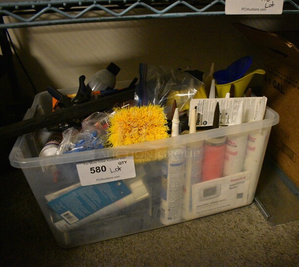 Plastic Tote With Various Items Including Ceramic Tile Caulk, Gorilla Glue, Silicone Sealant, and Funnels 