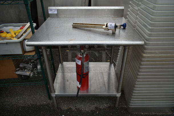 Stainless Steel Commercial Table w/ Back Splash and Under Shelf. Does Not Include Contents. - Image 1 of 3