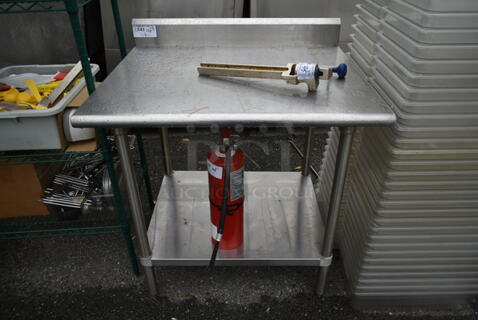 Stainless Steel Commercial Table w/ Back Splash and Under Shelf. Does Not Include Contents.