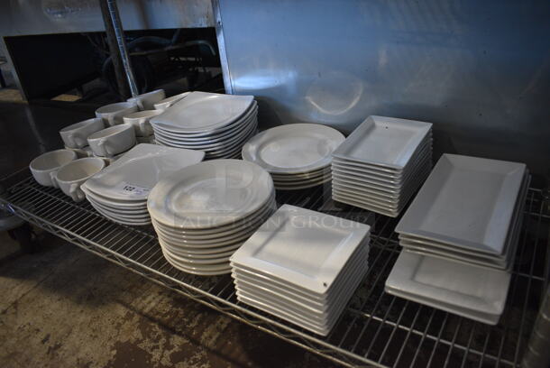 ALL ONE MONEY! Tier Lot of Various White Ceramic Dishes Including Approximately 14 Mugs and 57 Plates. Includes 9x9x1 
