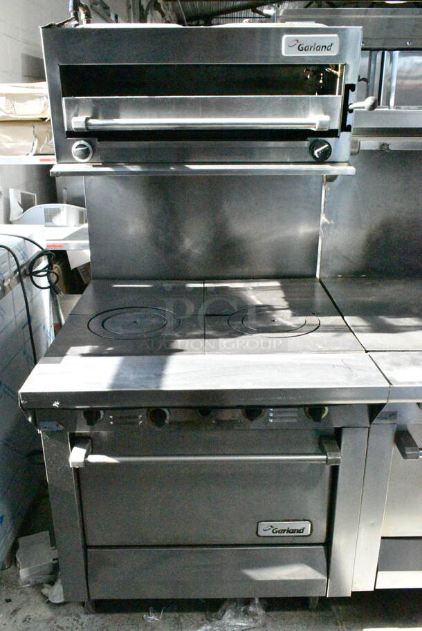 Garland M44T Stainless Steel Commercial Natural Gas Powered Flat Top w/ Oven, Salamander Cheese Melter and Back Splash on Commercial Casters. - Image 1 of 12