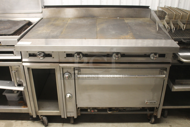 Jade Commercial Stainless Steel Heavy Duty Natural Gas Powered Range With Griddle Top And Standard Oven With Steel Racks On Commercial Casters.