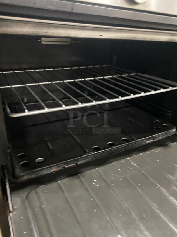 BEAUTIFUL! GARLAND All Stainless Steel Natural Gas Powered 6 Burner Range W/ Raised Right Side Flat Top W/ Cheese Melter! With 2 Ovens W/ Metal Racks! With Raised Over Back Splash & Slamander Shelf! On Legs! - Image 8 of 9