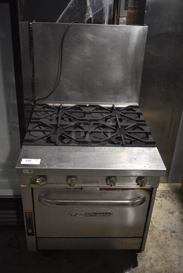 Southbend Stainless Steel Commercial Natural Gas Powered 4 Burner Range w/ Convection Oven and Back Splash on Commercial Casters.