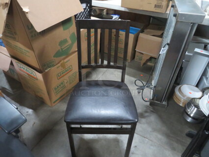 One Wooden Folding Chair With Black Cushioned Seat.