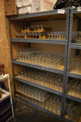 Gray Metal 5 Tier Shelving Unit w/ Contents Including Tall Glass Mugs and Wine Glasses. 48x24x72. BUYER MUST REMOVE; BUYER MUST DISMANTLE. PCI CANNOT DISMANTLE FOR SHIPPING. PLEASE CONSIDER FREIGHT CHARGES. (glass room - off of bar area)