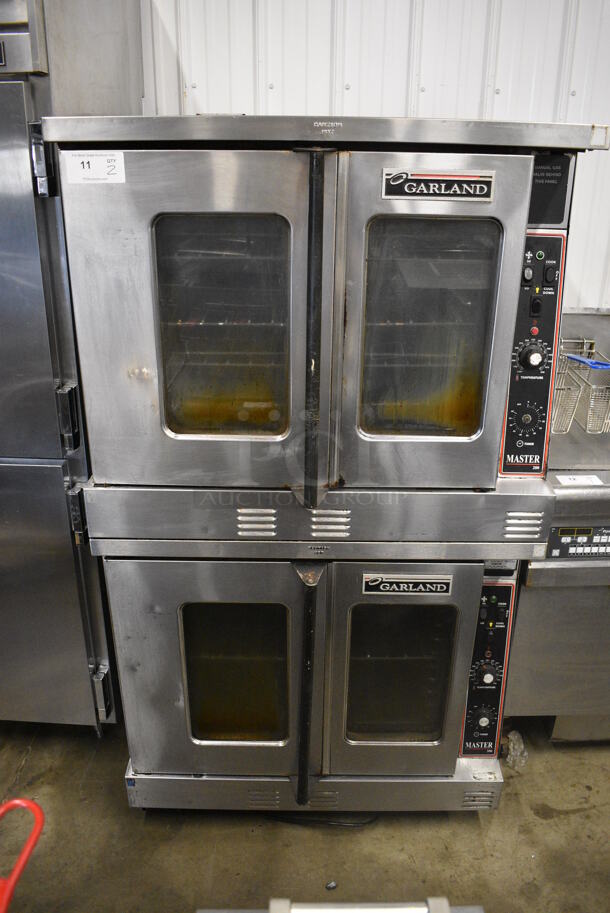 2 Garland Master 200 Stainless Steel Commercial Natural Gas Powered Full Size Convection Ovens w/ View Through Doors, Metal Oven Racks and Thermostatic Controls on Commercial Casters. 38x45.5x68. 2 Times Your Bid!