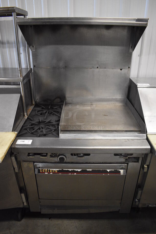 Garland Stainless Steel Commercial Natural Gas Powered 2 Burner Range w/ Flat Top Griddle, Oven, Back Splash and Over Shelf on Commercial Casters. 36x33x67