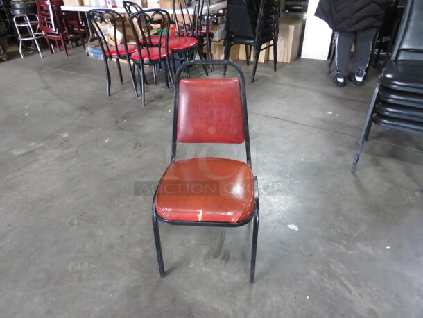One Black Metal Stack Chair With Orange Cushioned Seat And Back.  - Image 1 of 1