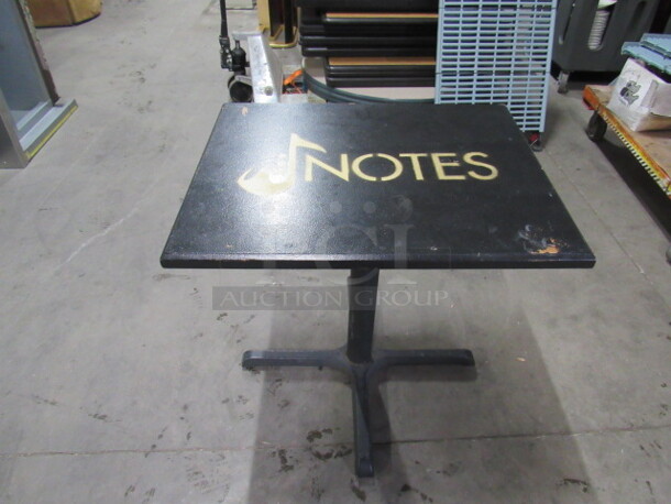 One Table Top Painted Black With The NOTES Logo, On A Pedestal Base. 30X24X30