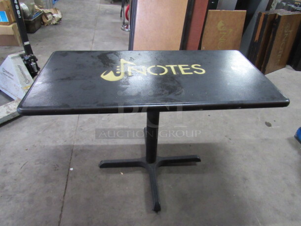 One Black Table Top With The NOTES Logo On A Pedestal Base. 47X24X30