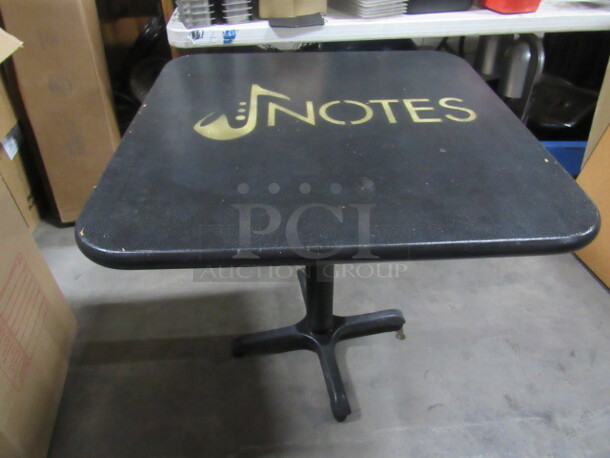 One Black  Table Top With The NOTES Logo On A Pedestal Base. 30X30X30