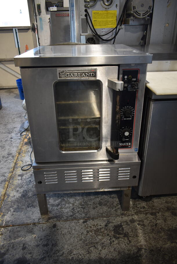 Garland MCO-E-5LE Master 200 Stainless Steel Commercial Natural Gas Powered Half Size Convection Oven w/ View Through Door, Metal Oven Racks and Thermostatic Controls on Metal Legs.