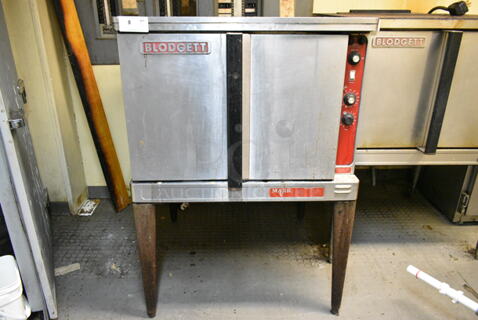 Blodgett Mark V Stainless Steel Commercial Electric Powered Full Size Convection Oven w/ Solid Doors, Metal Oven Racks and Thermostatic Controls on Metal Legs. This Unit Was In Working Condition When the Restaurant Closed. (kitchen)