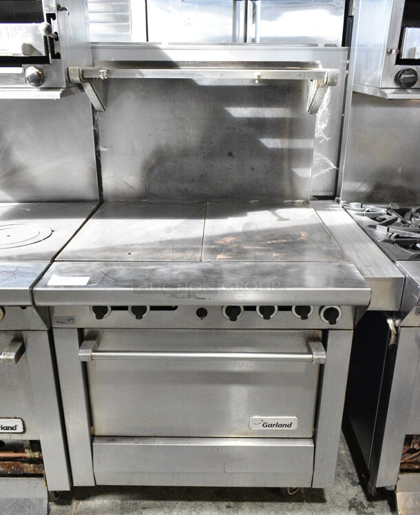 Garland M45R Stainless Steel Commercial Natural Gas Powered Flat Top w/ Oven, Over Shelf and Back Splash on Commercial Casters.  - Image 1 of 8
