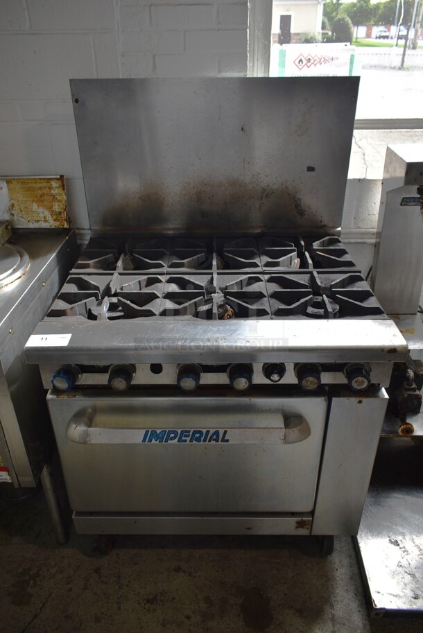 Imperial IR-6 Stainless Steel Commercial Natural Gas Powered 6 Burner Range w/ Oven and Back Splash on Commercial Casters.  - Image 1 of 7
