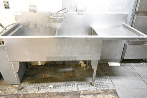 Stainless Steel Commercial 2 Bay Sink w/ Right Side Drain Board, Faucet and Handles. BUYER MUST REMOVE: Bring Tools and Manpower Needed To Remove This Item. (kitchen)