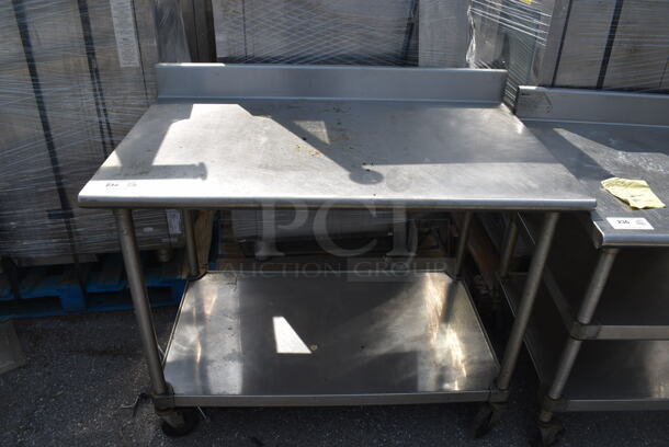 Commercial Stainless Steel Work Table With Backsplash And Undershelf On Commercial Casters.