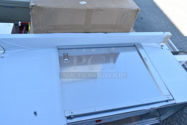 BRAND NEW SCRATCH AND DENT! Regency 600EBTB3072D 30" x 72" 16 Gauge Type 304 Stainless Steel Enclosed Base Sliding Door Table with Adjustable Midshelf and 6" Backsplash - Image 7 of 10
