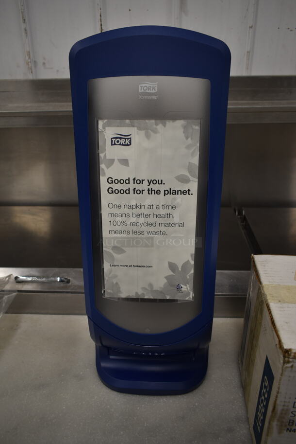 BRAND NEW IN BOX! Tork Blue and Clear Poly Napkin Dispenser. - Image 1 of 5