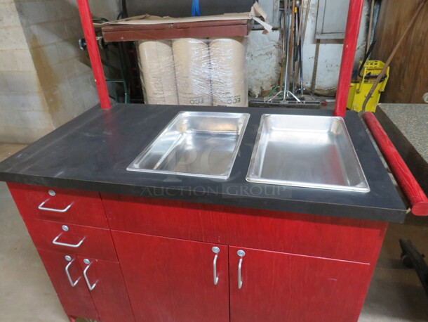 One Red Wood Work Station/Kiosk With A Black Laminate Top, 2 Full Size Hotel Pans, Push Bar,  4 Doors, And 2 Drawers, On Casters. 48X25X36 - Image 2 of 3