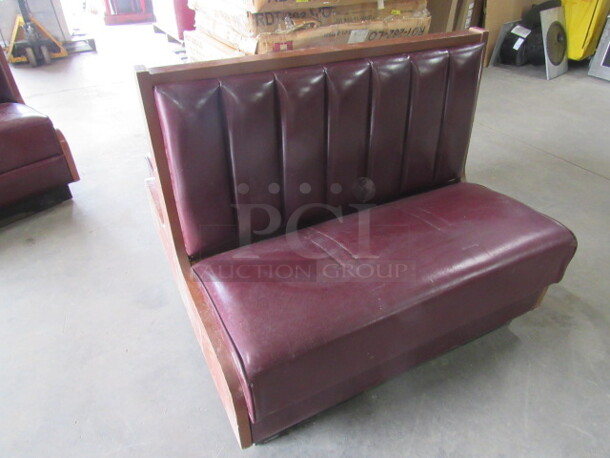 One Wooden Single Sided Booth With Burgundy Cushioned Seat And Back.