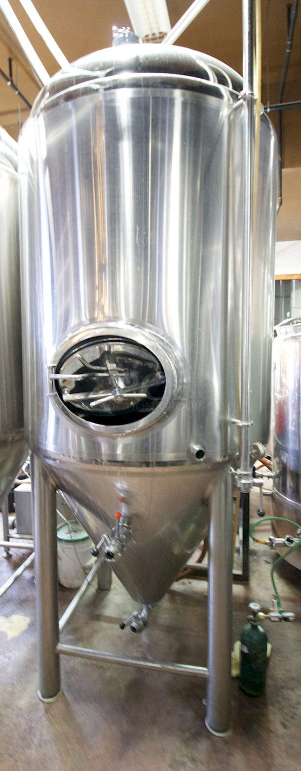 ? ? BEAUTIFUL!! Stout Tanks & Kettles - 15 BBL Fermenter / Unitank (Jacketed). ? ? Features: Easily Converts to a Unitank or Brite Serving Tank; Glycol Jacketed - 2 Zones: Cone and Sidewall; Shadowless Manway for Easy Cleaning; Adjustable Racking Arm for Clear Transfer; 1.5" Sample Valve for Quality Testing; Back Mounted Pressure Gauge; Adjustable Feet for Leveling on Uneven Floors or Fine Height Adjustments; Pressure Gauge Type: Back Mount; CIP Arm and 2.5" Rotating CIP Spray Ball; 2 Butterfly Valves; Rated to 2-Bar (29 PSI); 1/2" NPT Welded Thermowell for Contactless Temperature Probe Tank Thickness: 3mm Jacket and Outer Shell Thickness: 2mm. Cone: 60 degree Interior Angle. 51.5-in. diameter x 125-in.H. - Image 7 of 8