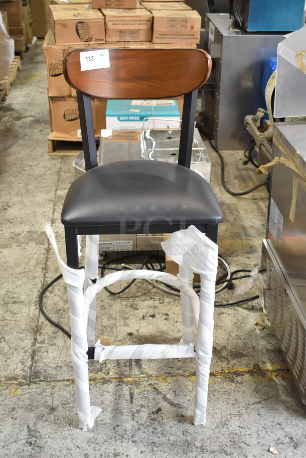 BRAND NEW SCRATCH AND DENT! Lancaster Table & Seating Black Metal Bar Height Chair w/ Black Seat Cushion and Wooden Back Rest.  - Image 1 of 3