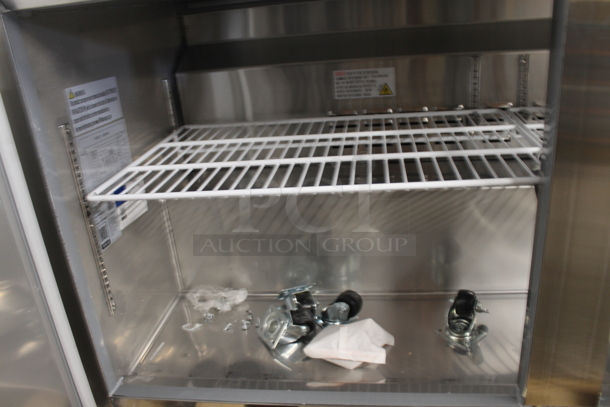 BRAND NEW SCRATCH AND DENT!  Avantco 178SSWT60FHC Commercial Stainless Steel Two Door Worktop Freezer With Backsplash, Polycoated Racks And Commercial Casters. 115V. Tested and Working! - Image 4 of 8